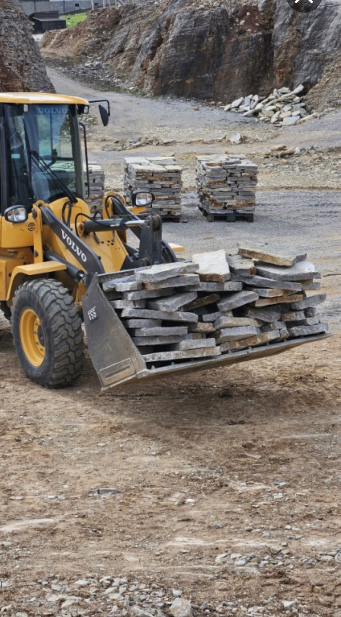 Radlader transportiert Natursteinplatten